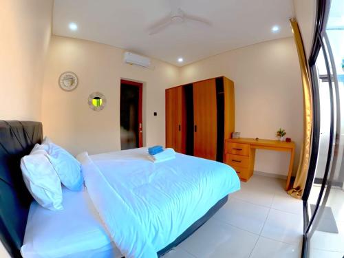 a bedroom with a large bed and a desk at Best Value Room Sanur Walk to Beach - NVB in Sanur