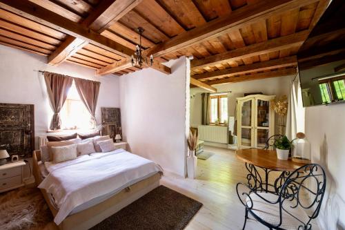 a bedroom with a bed and a table in it at PusztaFarm - Boutique Retreat with Wellness 6 to 8 Guests in Fülöpháza