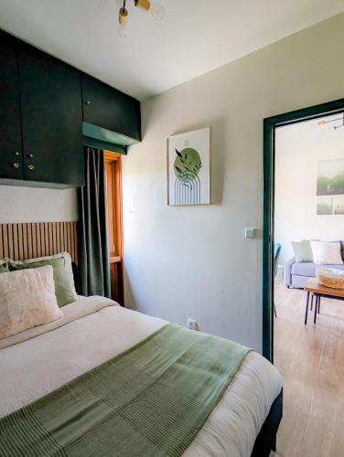 a bedroom with a bed and a room with a couch at L'émeraude Waulsort in Waulsort