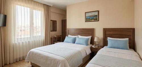 a hotel room with two beds and a window at Kaptanlar in Side