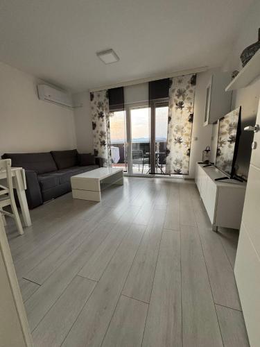 a living room with a couch and a table at White Horizon Apartment in Teslić