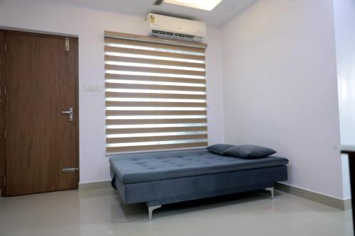a bedroom with a bed in a room with a window at Vaiga Heavens - 1 BHK Apartment, 500 m to temple in Guruvāyūr