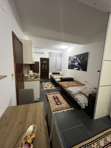 a room with two beds and a table and a kitchen at Household Grbovic in Bijelo Polje