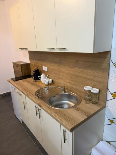 a kitchen counter with a sink and white cabinets at Household Grbovic in Bijelo Polje
