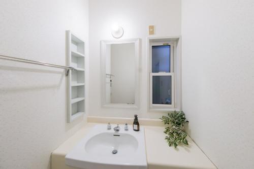 a white bathroom with a sink and a window at Shakunagedaira Rental cottage - Vacation STAY 18459v in Numanokura