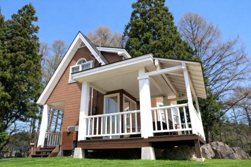 a house with a porch and a rock at Shakunagedaira Rental cottage - Vacation STAY 18459v in Numanokura