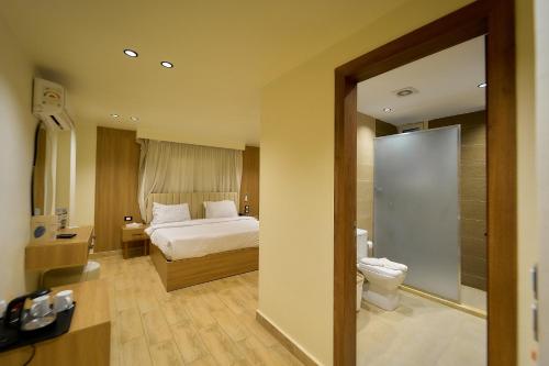 a hotel room with a bed and a bathroom at Merak Pyramids Hotel in Cairo