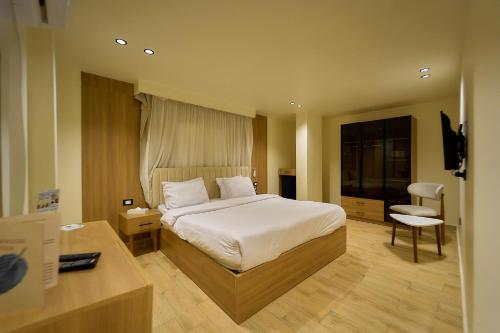 a bedroom with a bed and a desk and a chair at Merak Pyramids Hotel in Cairo