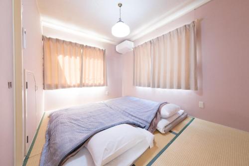 a bedroom with a bed in a room with pink walls at Shakunagedaira Rental cottage - Vacation STAY 18463v in Numanokura