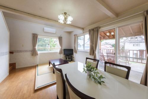 a living room with a dining room table with chairs and a dining room at Shakunagedaira Rental cottage - Vacation STAY 18464v in Numanokura