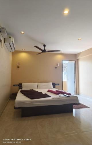 a bedroom with a large bed with a ceiling fan at The K Inn Wavefront in Mahabalipuram