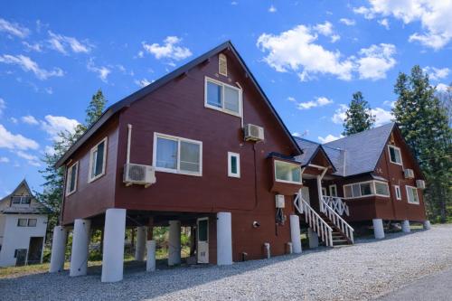 a large red house with white columns at Shakunagedaira Rental cottage - Vacation STAY 18464v in Numanokura