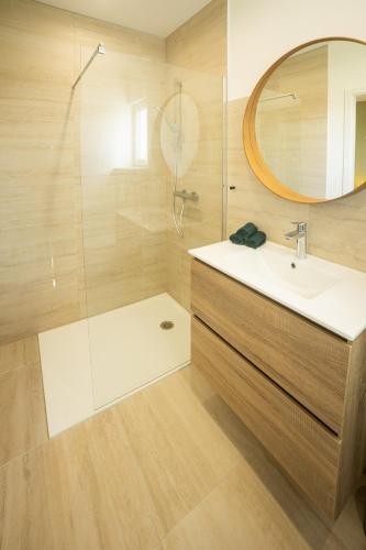 a bathroom with a sink and a shower with a mirror at Lodge Romy in Schalkendorf