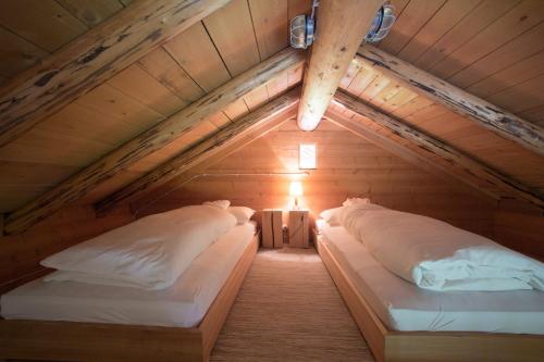 two beds in a room with a attic at Berghütte Blockhaus in Redagno