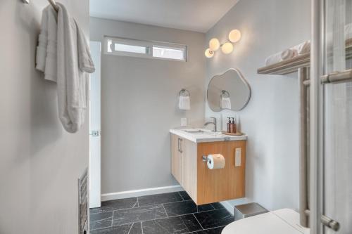 a bathroom with a sink and a toilet and a mirror at Modern Luxury Sierra Lodge | 3BR, 3BA | Hotel Vibe in Groveland