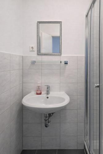 a white bathroom with a sink and a mirror at Monteurzimmer deSoL in Forst