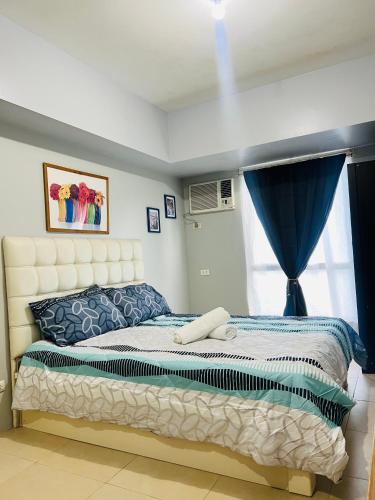 a bedroom with a bed and a window at Avida Towers Riala Tower inside IT Park Cebu City in Cebu City