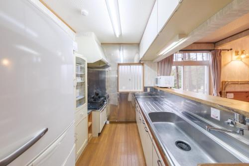 a large kitchen with a sink and a counter at Shakunagedaira Rental cottage - Vacation STAY 18466v in Numanokura