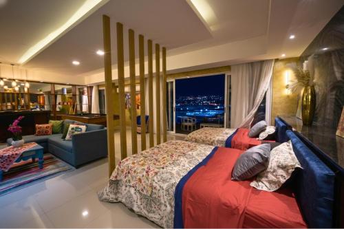 a bedroom with two beds and a living room at Loft tipo Penthouse con terraza panorámica y mesa de billar in Monterrey