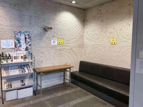 a waiting room with a bench and a table at Sankei City Hotel Hachioji in Hachioji