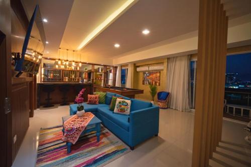 a living room with a blue couch and a table at Loft tipo Penthouse con terraza panorámica y mesa de billar in Monterrey