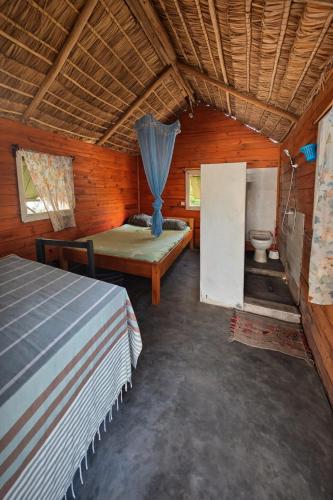 a bedroom with a bed and a toilet in a room at Chez Émile in Anakao