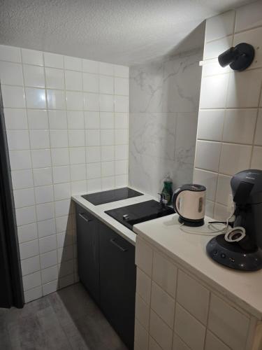 a small kitchen with a stove and a sink at Ocean 300m Gare Centre ville Wifi Parking gratuit in Belfort