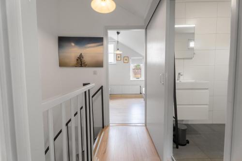 a hallway with white walls and a staircase with a sink at Spaanse Galeien 16 in Retranchement