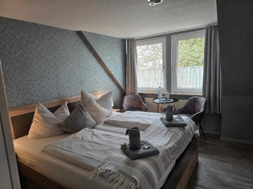 una camera da letto con un letto con due sedie e una finestra di Hotel Up Diek a Carolinensiel
