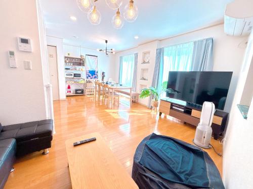 a living room with a large television and a table at Ikebukuro area, three layer house, double subway,5 min walk to stn, 双地铁车站步行5分 直达新宿 涩谷 银座 池袋 皇居 可免费停车 最大10人 in Tokyo