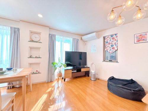 a living room with a television and a table at Ikebukuro area, three layer house, double subway,5 min walk to stn, 双地铁车站步行5分 直达新宿 涩谷 银座 池袋 皇居 可免费停车 最大10人 in Tokyo