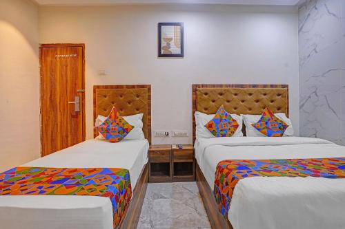 a hotel room with two beds with colorful pillows at FabHotel Beverly Plaza in Mumbai