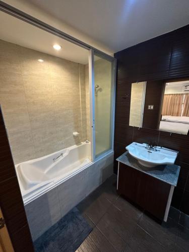 a bathroom with a tub and a sink and a bath tub at Uptown Condotel in Bulwa