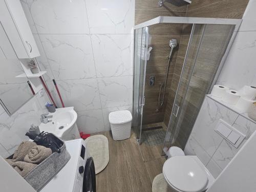 a bathroom with a shower and a toilet and a sink at Apartman IVA in Modriča