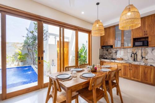 a kitchen and dining room with a table and chairs at Villa Surga in Denpasar