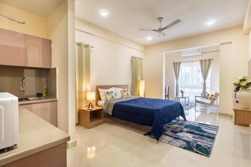 a bedroom with a blue bed and a kitchen at Altura in Bangalore