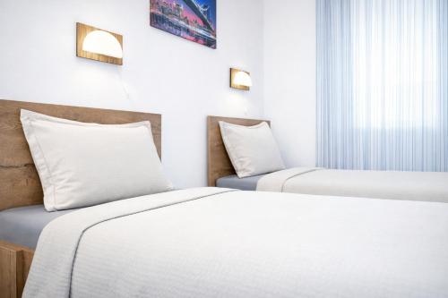 a hotel room with two beds and a window at Hotel Road Rooms in Voluntari
