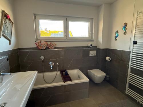 a bathroom with a tub and a toilet and a sink at Wohnung Kirchstein Highlight Fliegenfischen auf der Isar in Lenggries
