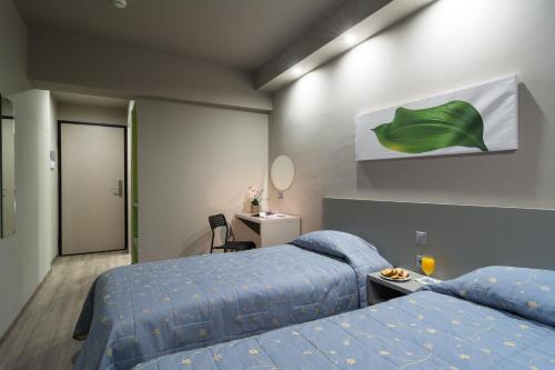 a hotel room with two beds and a mirror at Vergina Hotel in Thessaloniki