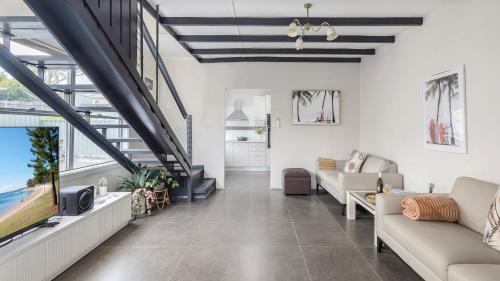 a living room with a couch and a tv at Shoal Sanctuary in Nelson Bay