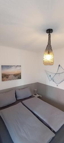 a bedroom with a bed and a light fixture at Juliusruh Strandparadies 9 in Juliusruh