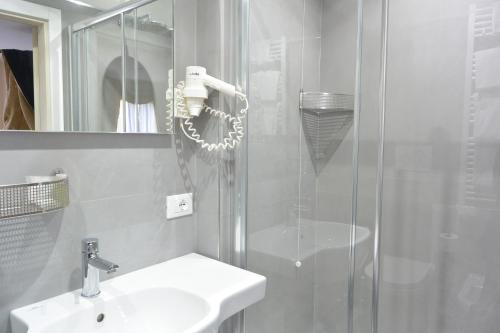 a bathroom with a shower and a sink and a mirror at Hotel San Zulian in Venice