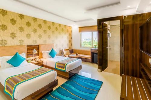 a hotel room with two beds and a bathroom at OPO Horizon LYRO Hotel , Formerly known as Inde Hotel in Gurgaon