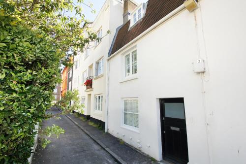 a white building with a black door on a street at Marine Gardens - Central - by Brighton Holiday Lets in Brighton & Hove