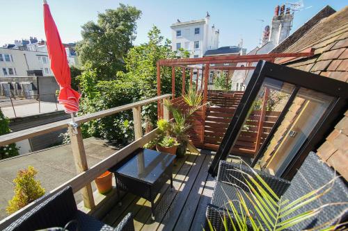 a balcony with a glass table and an umbrella at Marine Gardens - Central - by Brighton Holiday Lets in Brighton & Hove