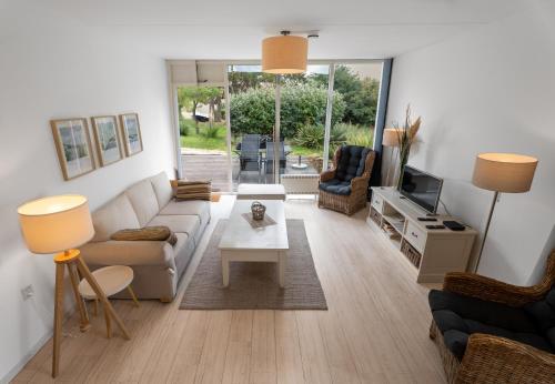 a living room with a couch and a table at Erdgeschoss-Wohnung nahe am Meer in Cadzand