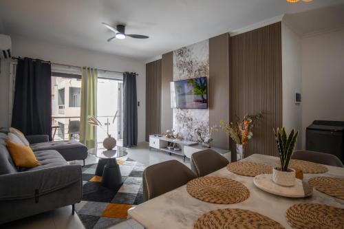 a living room with a couch and a table with chairs at Tropical Escape Flic en Flac in Flic-en-Flac