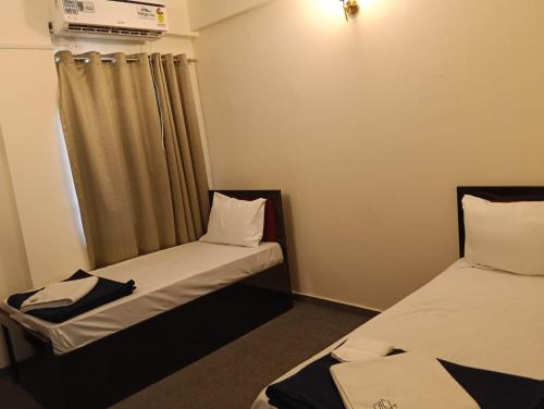 two beds in a small room with a window at Dia Inn in Bori