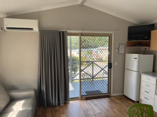 a kitchen with a sliding glass door to a balcony at Clarence Head Caravan Park in Iluka