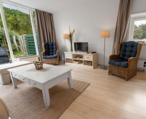 a living room with a coffee table and two chairs at Erdgeschoss-Wohnung nahe am Meer in Cadzand